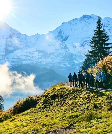 Travellers hiking through the Swiss Alps with panoramic mountain views on the Contiki Active Swiss Alps Tour