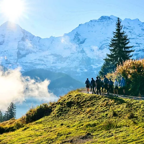 Travellers hiking through the Swiss Alps with panoramic mountain views on the Contiki Active Swiss Alps Tour