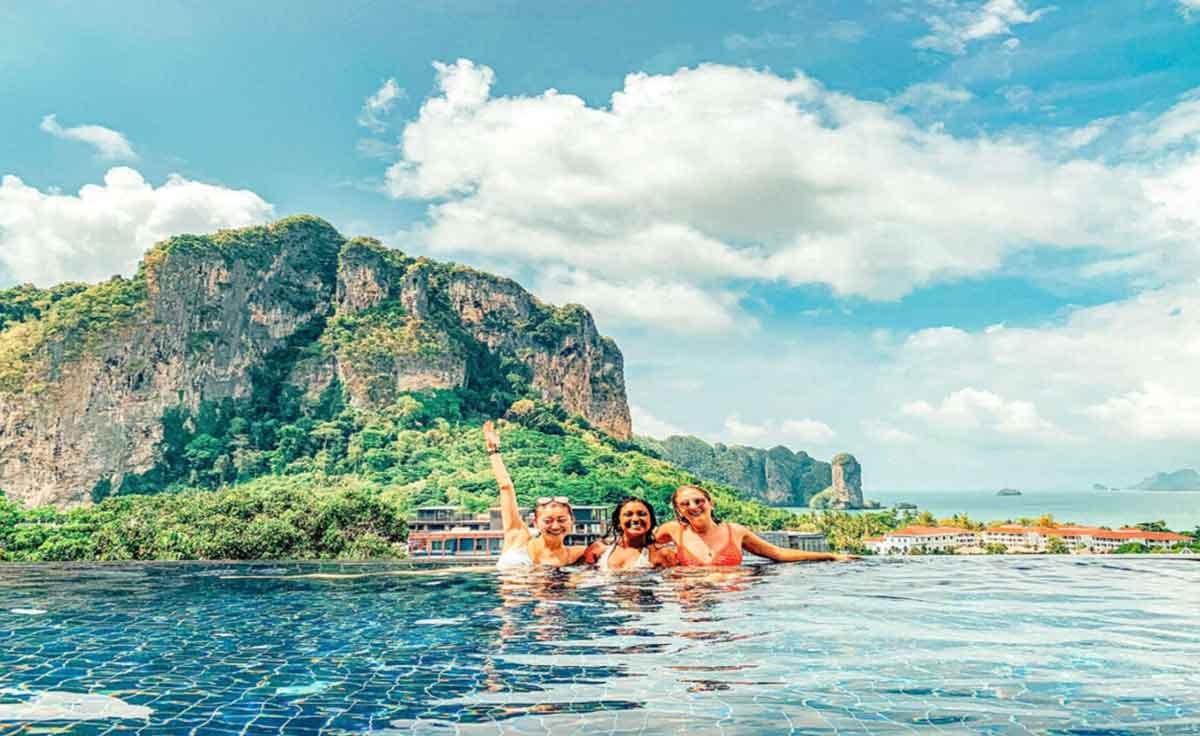 Group Enjoying A Pool With A View In Thailand