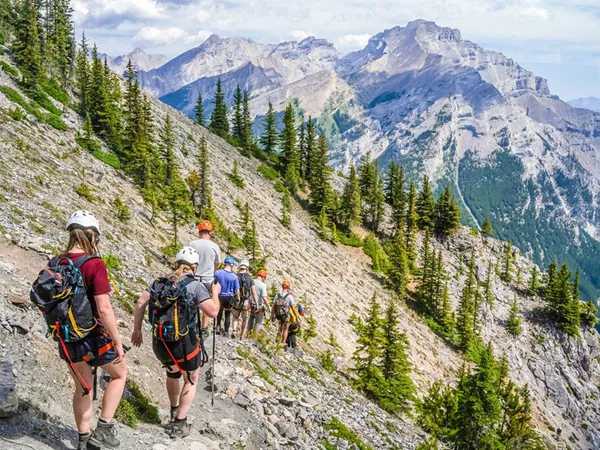 Group Of People Hiking Snowy Mountain As Background