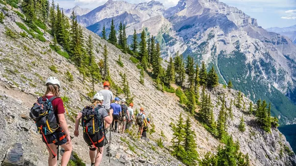 Group Of People Hiking Snowy Mountain As Background