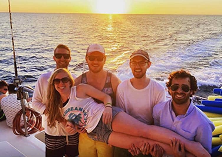 A group of men holding a smiling woman on their hands