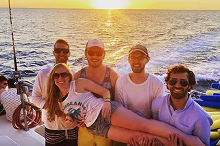 A group of men holding a smiling woman on their hands