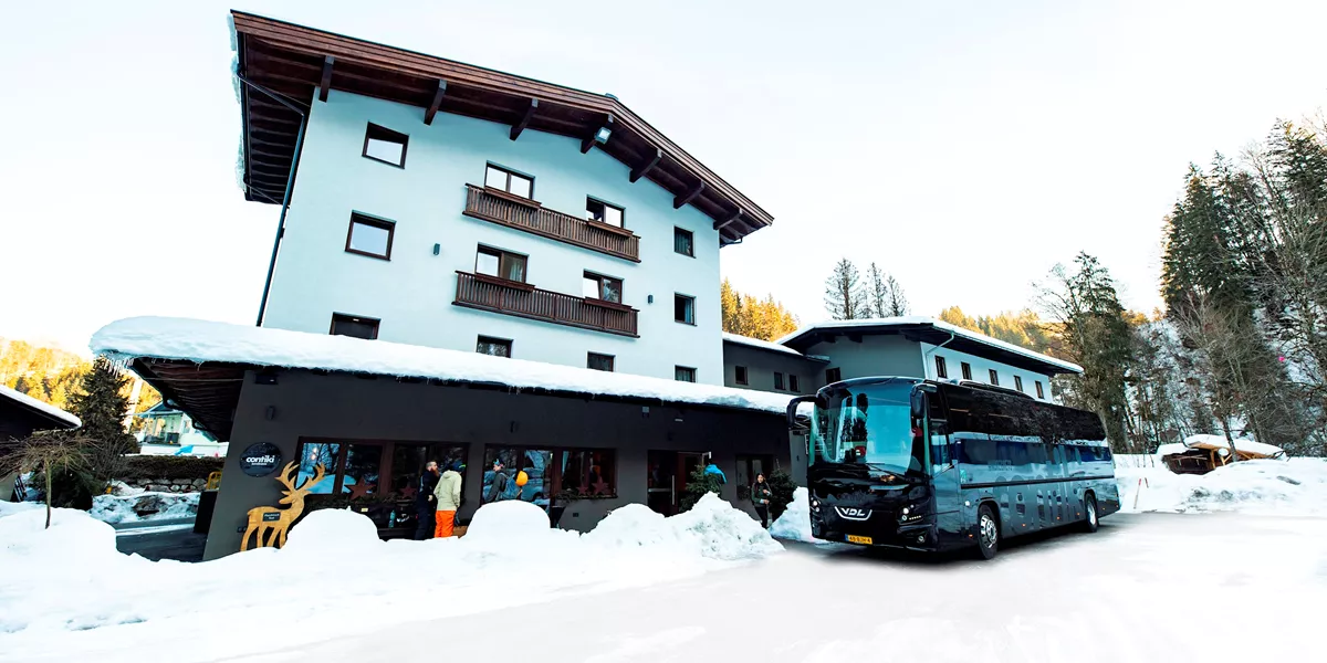 Travellers laughing in the snow in the town of Hopfgarten, Austria