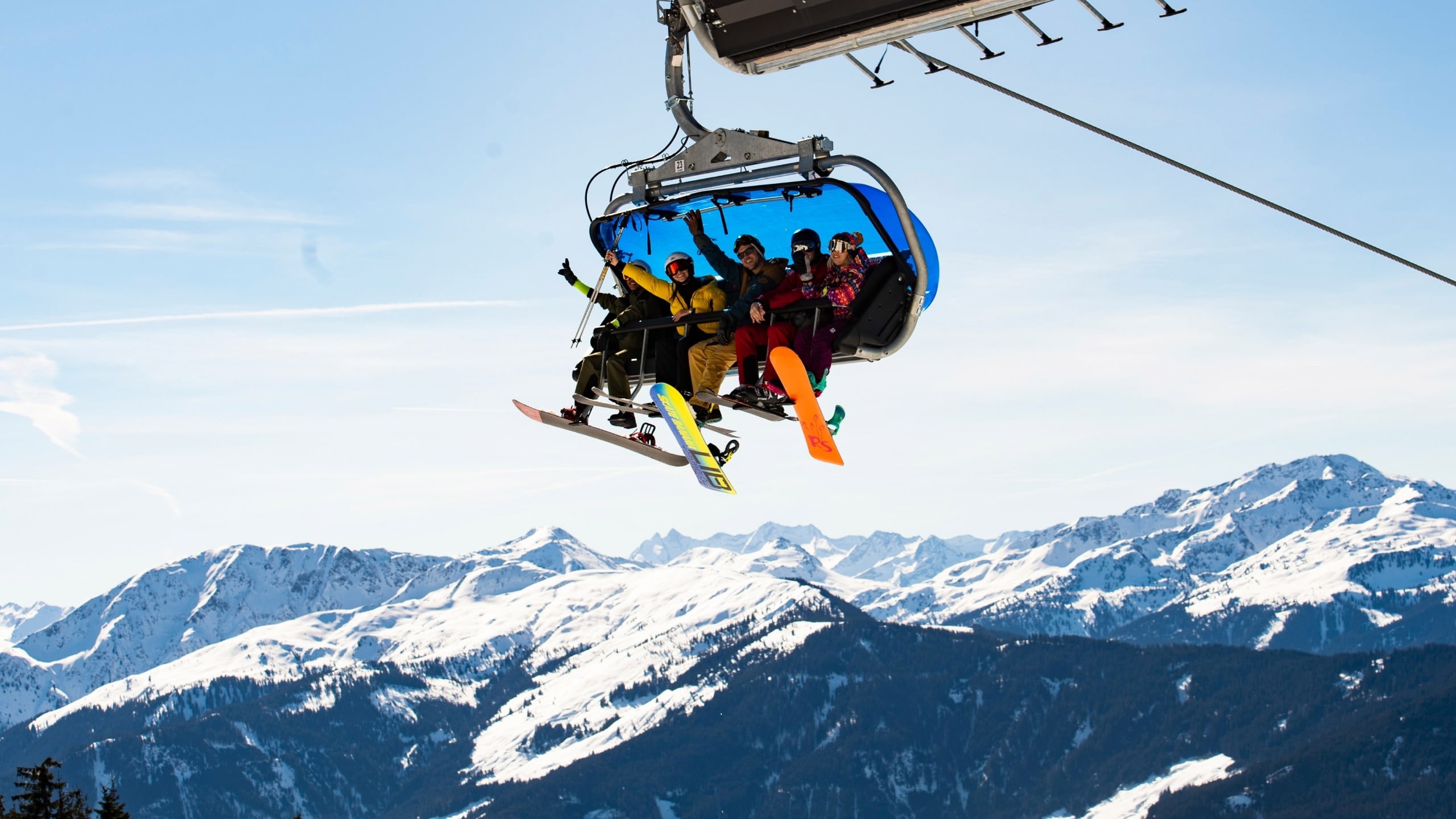 Travellers riding a chairlift with panoramic views of the Austrian Alps on the Contiki Ski Austria 35 to 45 Tour