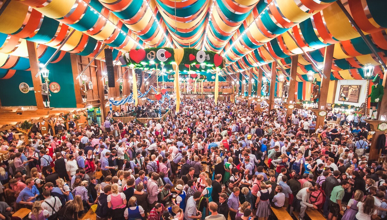Travellers experiencing Oktoberfest in an Oktoberfest tent in Munich, Germany