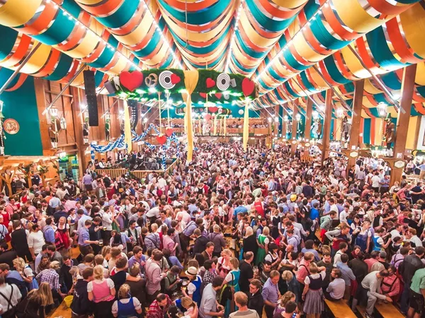 Travellers experiencing Oktoberfest in an Oktoberfest tent in Munich, Germany