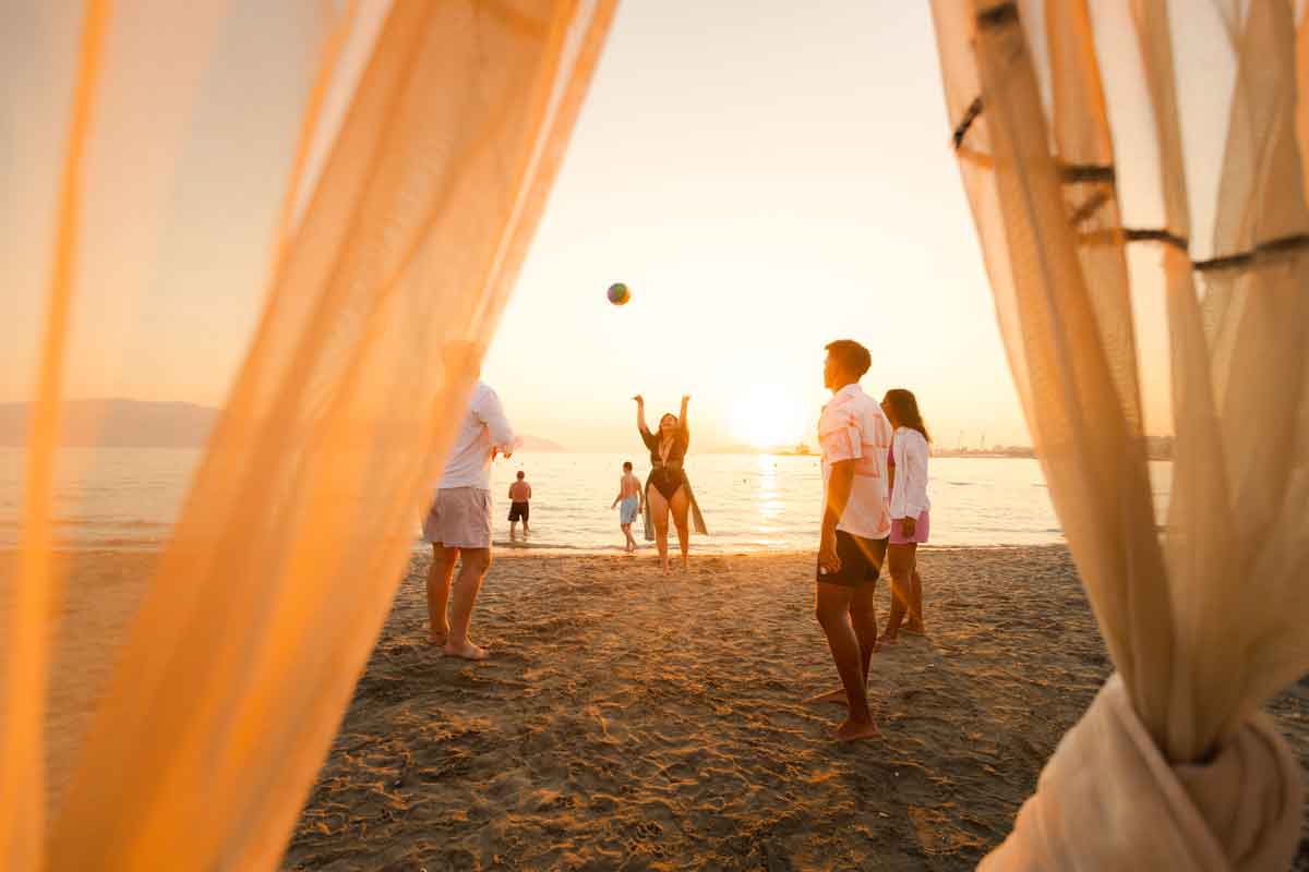 Group Of People On The Beach Playing Volley Ball