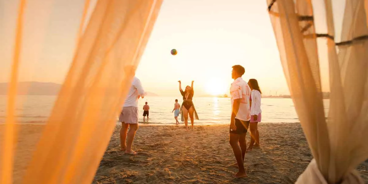 Group Of People On The Beach Playing Volley Ball