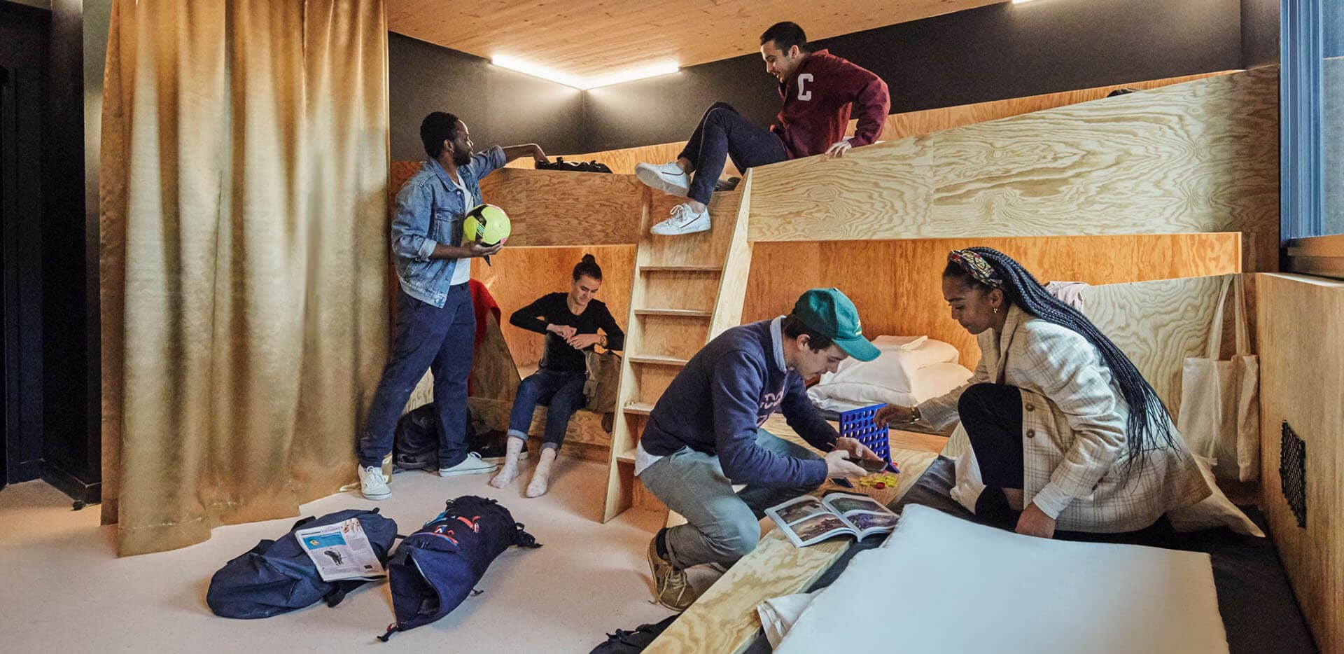 A group of people sitting on wooden bunk beds