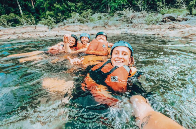 Group enjoying a water adventure in helmets and life vests.