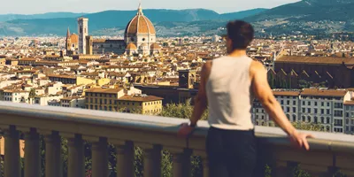 Traveller at Piazzale Michelangelo overlooking the Florence skyline with Brunelleschi's Duomo and Campanile in Tuscany Italy - Contiki European Discovery Tour