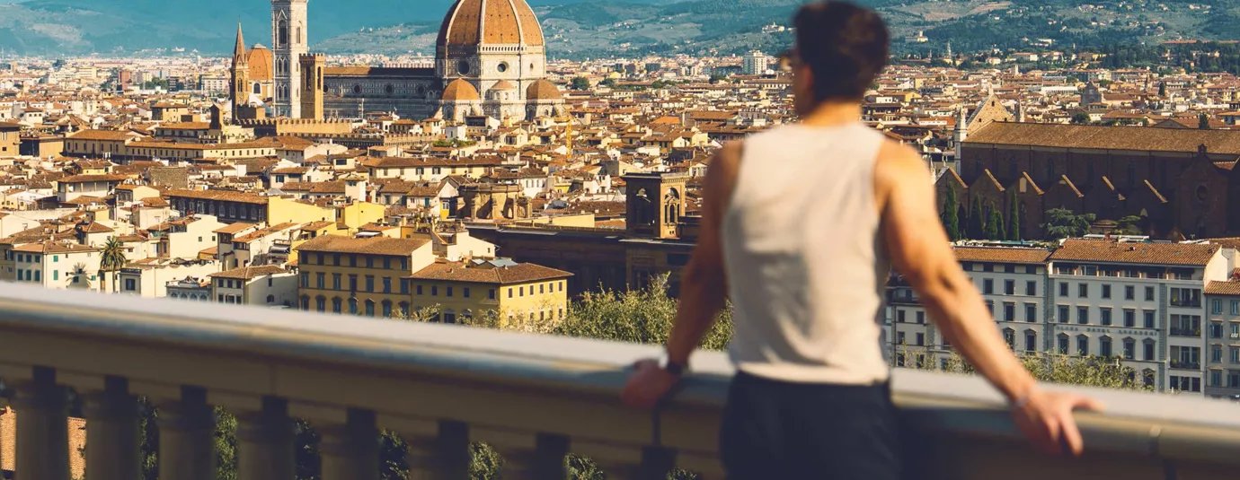 Traveller at Piazzale Michelangelo overlooking the Florence skyline with Brunelleschi's Duomo and Campanile in Tuscany Italy - Contiki European Discovery Tour
