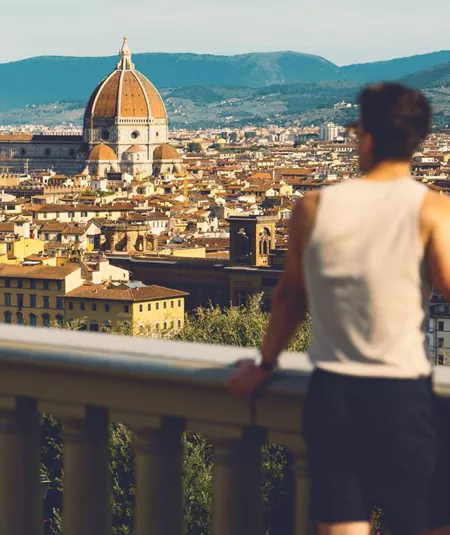 Traveller at Piazzale Michelangelo overlooking the Florence skyline with Brunelleschi's Duomo and Campanile in Tuscany Italy - Contiki European Discovery Tour