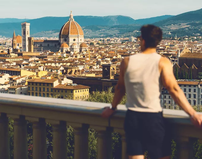 Traveller at Piazzale Michelangelo overlooking the Florence skyline with Brunelleschi's Duomo and Campanile in Tuscany Italy - Contiki European Discovery Tour