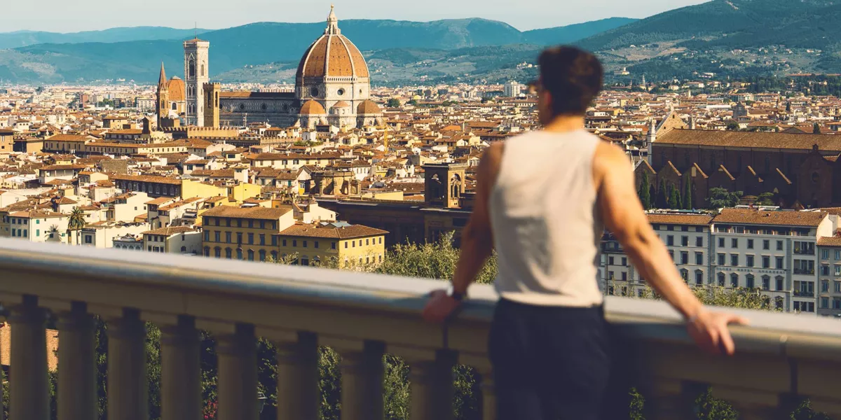 Traveller at Piazzale Michelangelo overlooking the Florence skyline with Brunelleschi's Duomo and Campanile in Tuscany Italy - Contiki European Discovery Tour