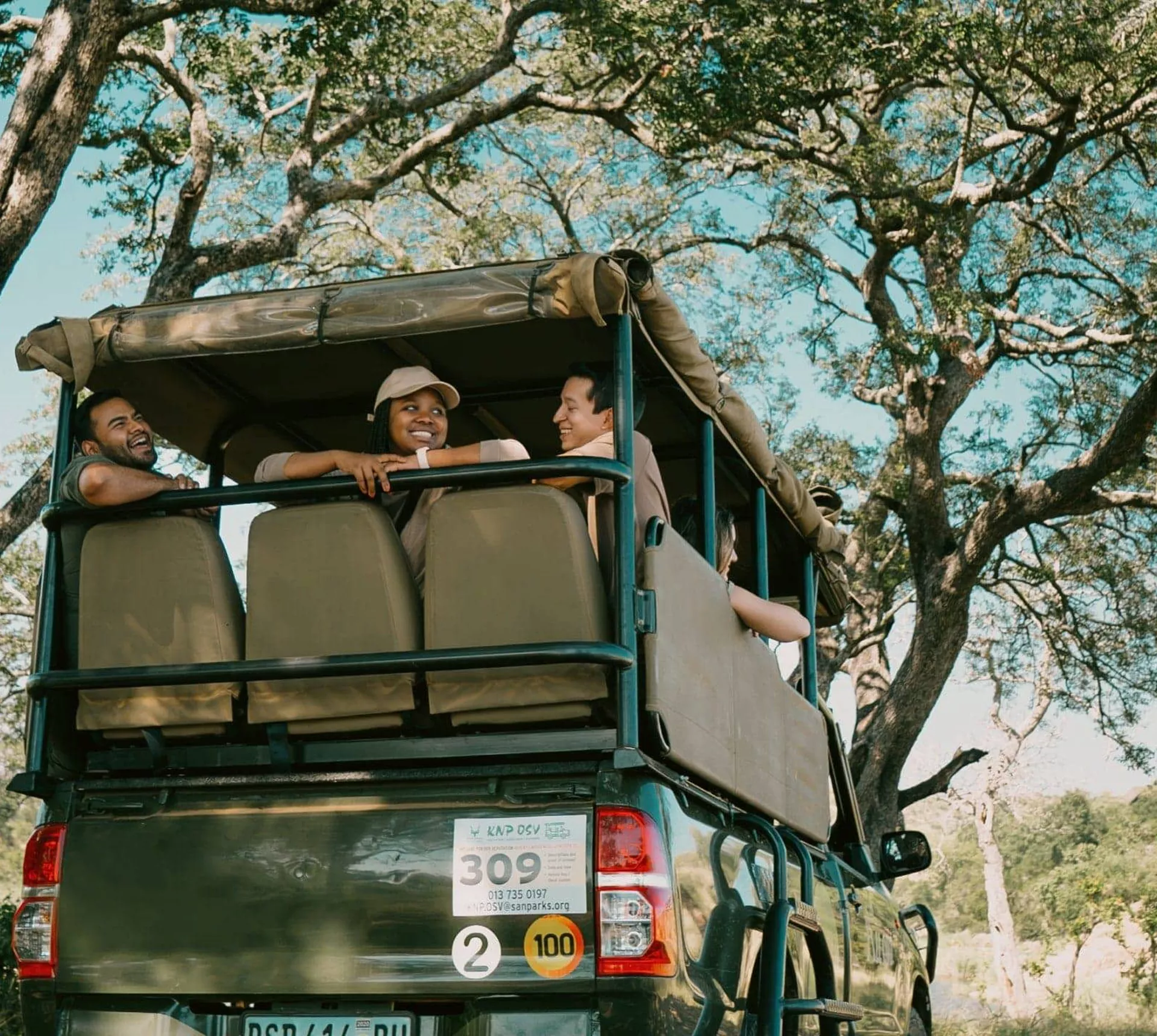 Travellers riding in an open safari vehicle during a game drive - Contiki South Africa & Botswana Safari Tour