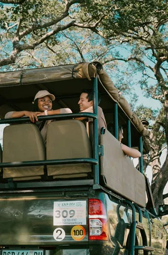 Travellers riding in an open safari vehicle during a game drive - Contiki South Africa & Botswana Safari Tour