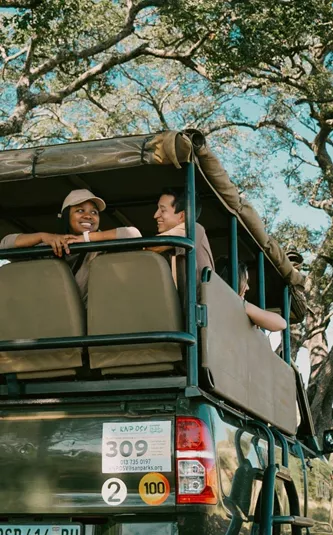 Travellers riding in an open safari vehicle during a game drive - Contiki South Africa & Botswana Safari Tour