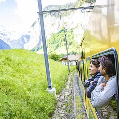 Travellers leaning out of a window in a train