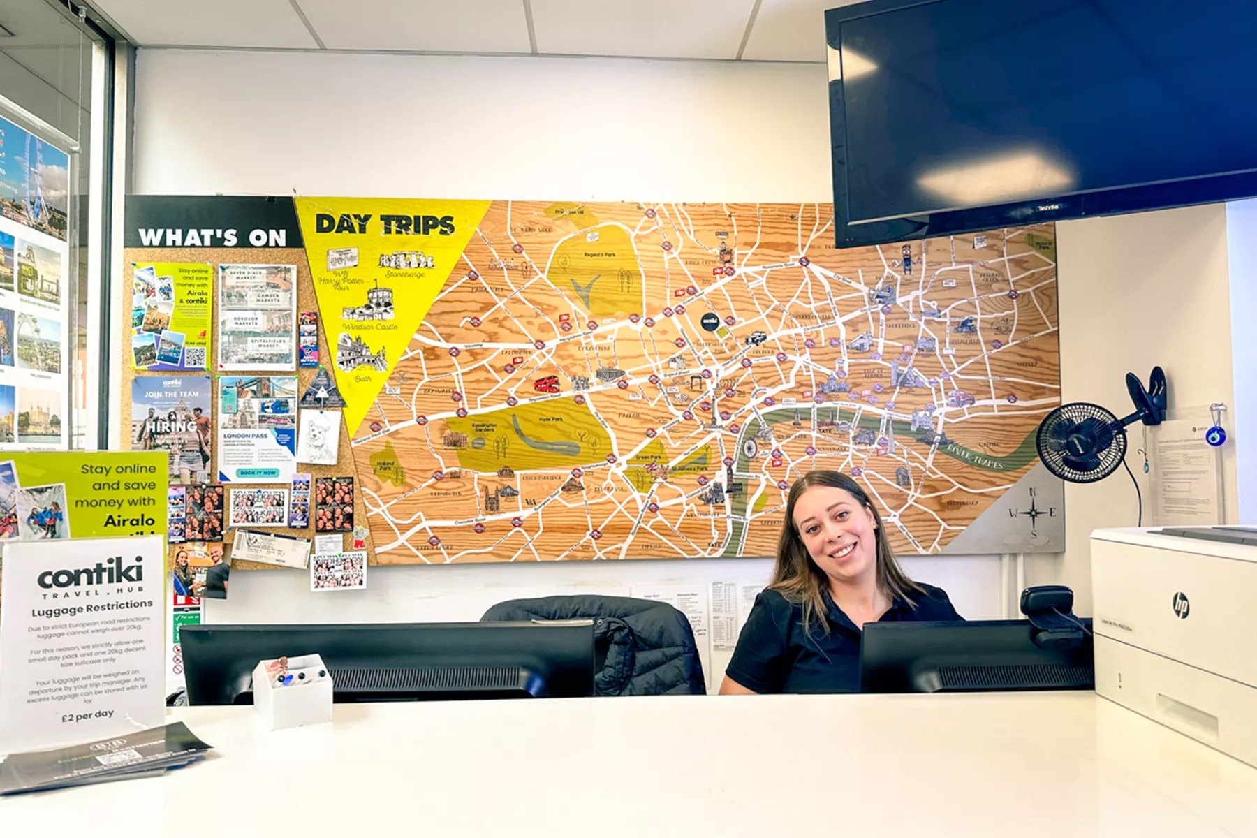 Team member smiling behind desk in Contiki office