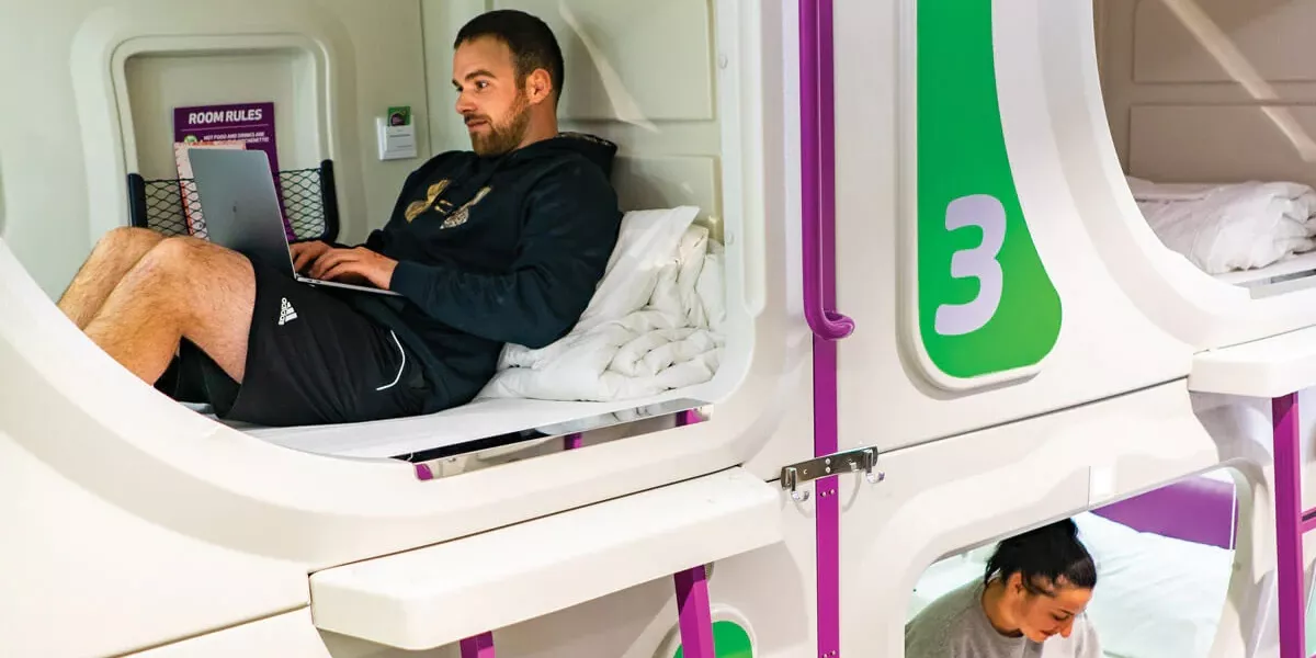 A man and a woman sitting on their beds