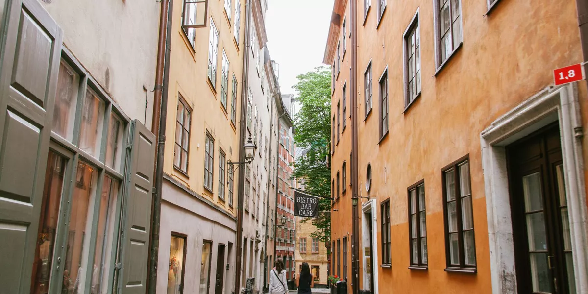 Two Friends Walking In A Narrow City Street