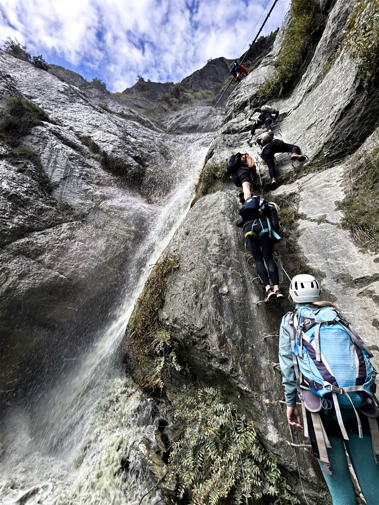 Travellers taking on the Lord of the Rungs Waterfall Climb, Wānaka, New Zealand