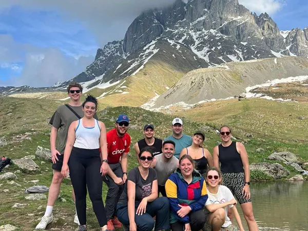 Large Group Of People Smiling Rocky Mountain At The Back