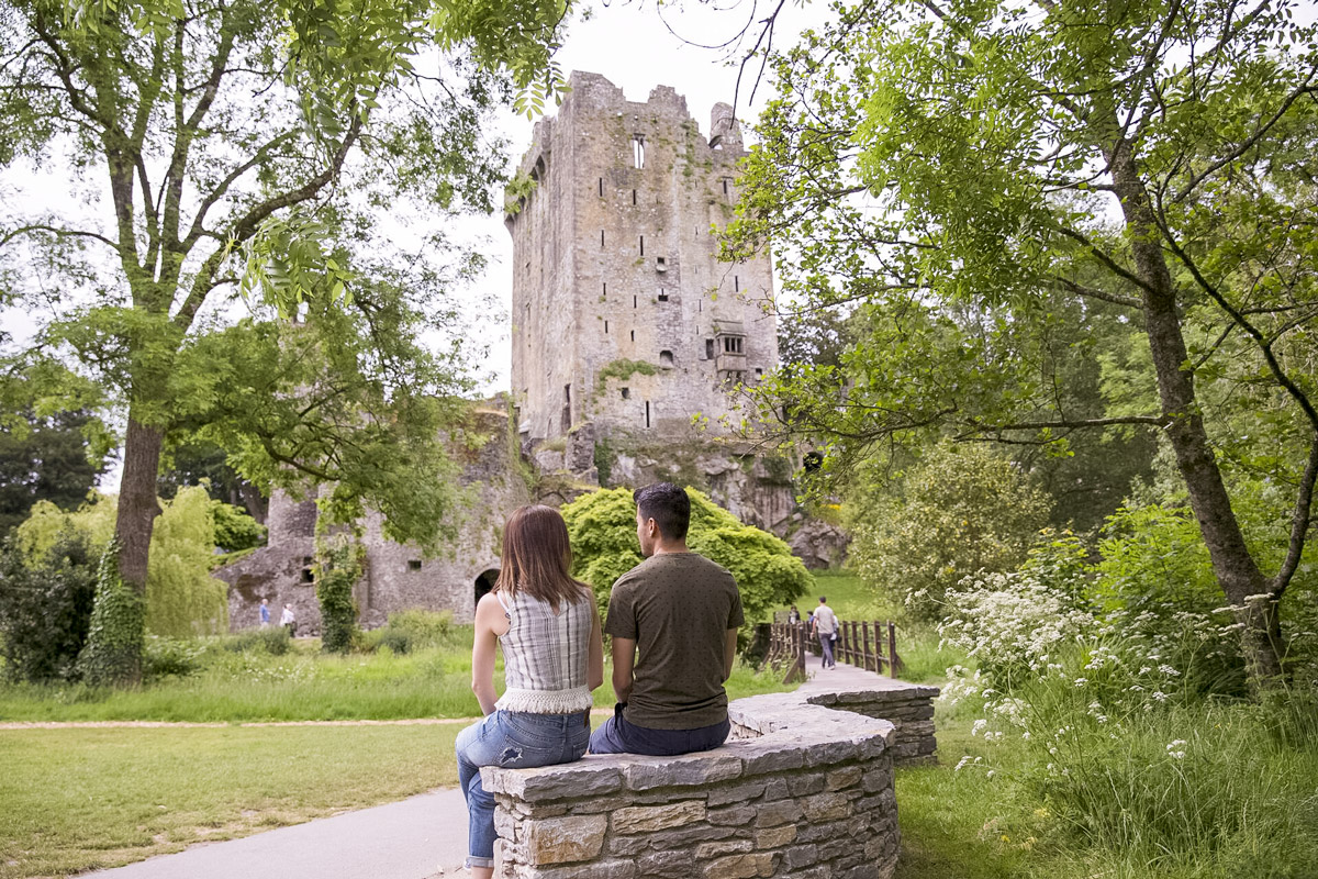 Couple Sitting Looking At Castle And Gardens in Ireland.