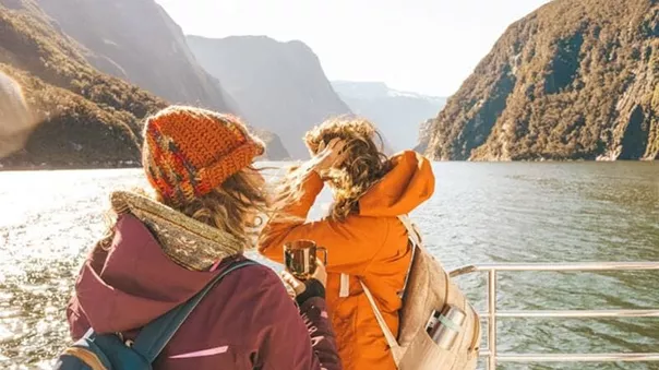 Warmly dressed women on a boat sailing among the hills