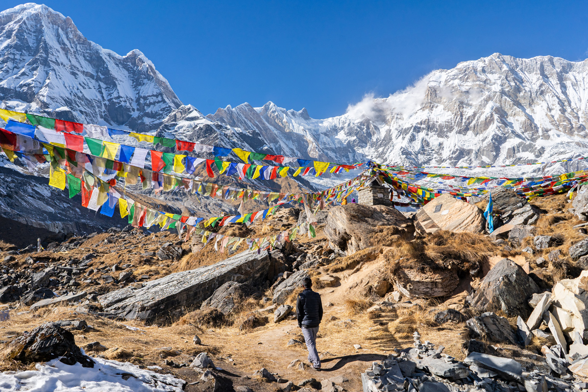 Man Looking At Snowy Mountains Colourful Squre Fabrics Hanging From Robe