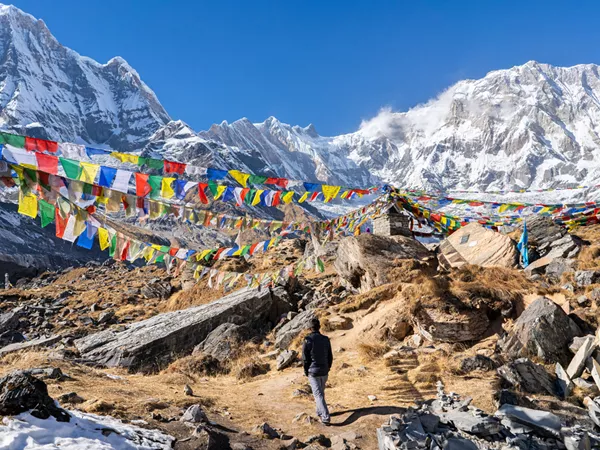 Man Looking At Snowy Mountains Colourful Squre Fabrics Hanging From Robe