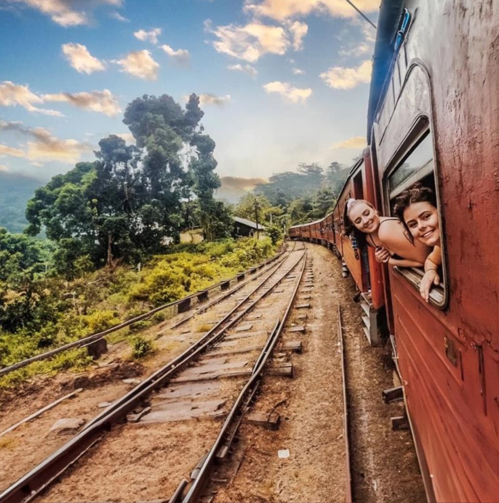 Travellers Leaning Out Of A Train In Sri Lanka