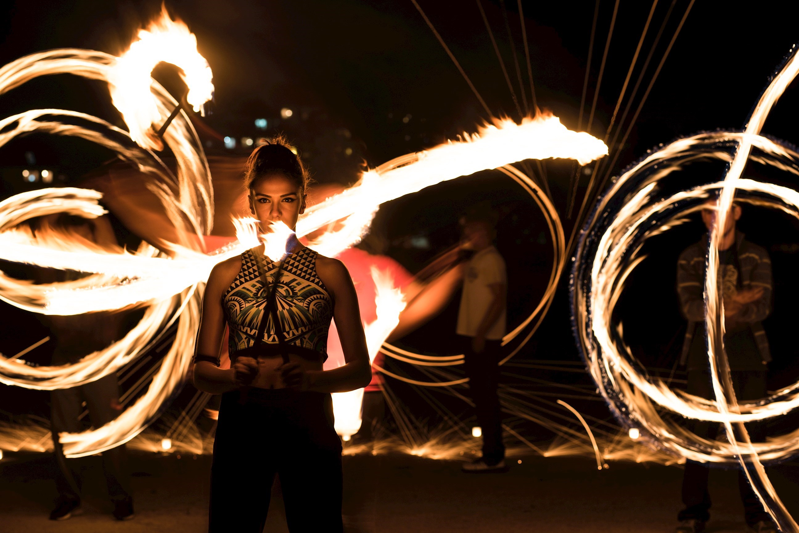 Performer standing and holding flaming torch with fire light painting behind in Shanghai, China
