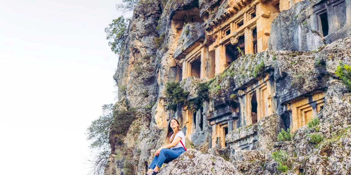 Woman Sitting On A Rock Landmark As Her Background