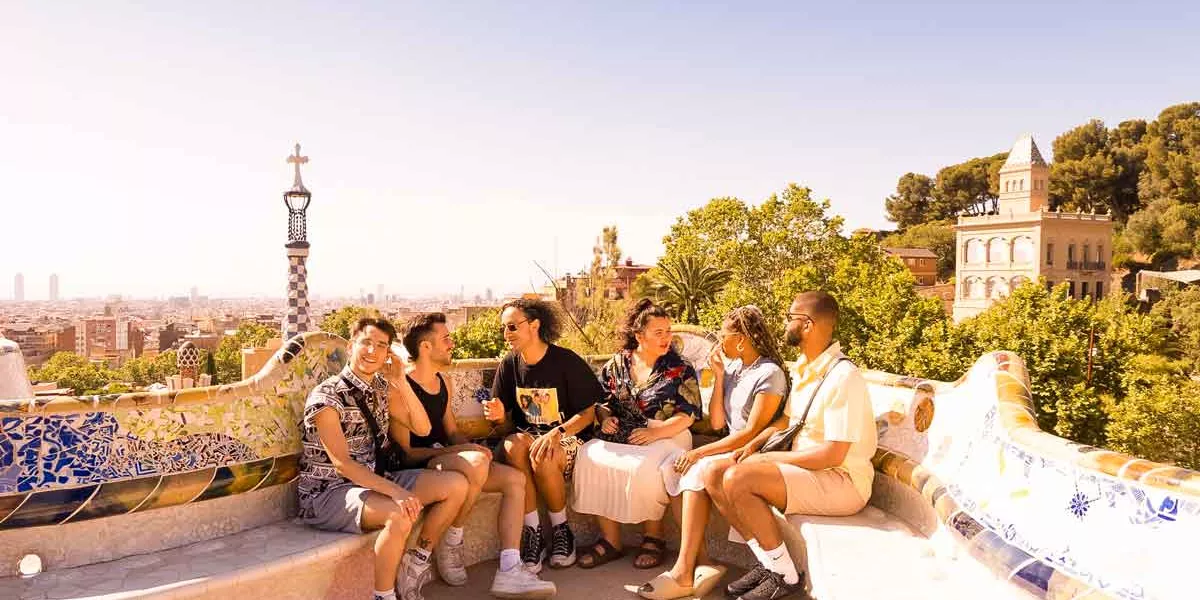 Young Travellers Sitting In The Sun In Barcelona
