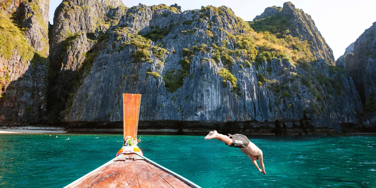 Man Diving From Boat Prow Phi Phi Island