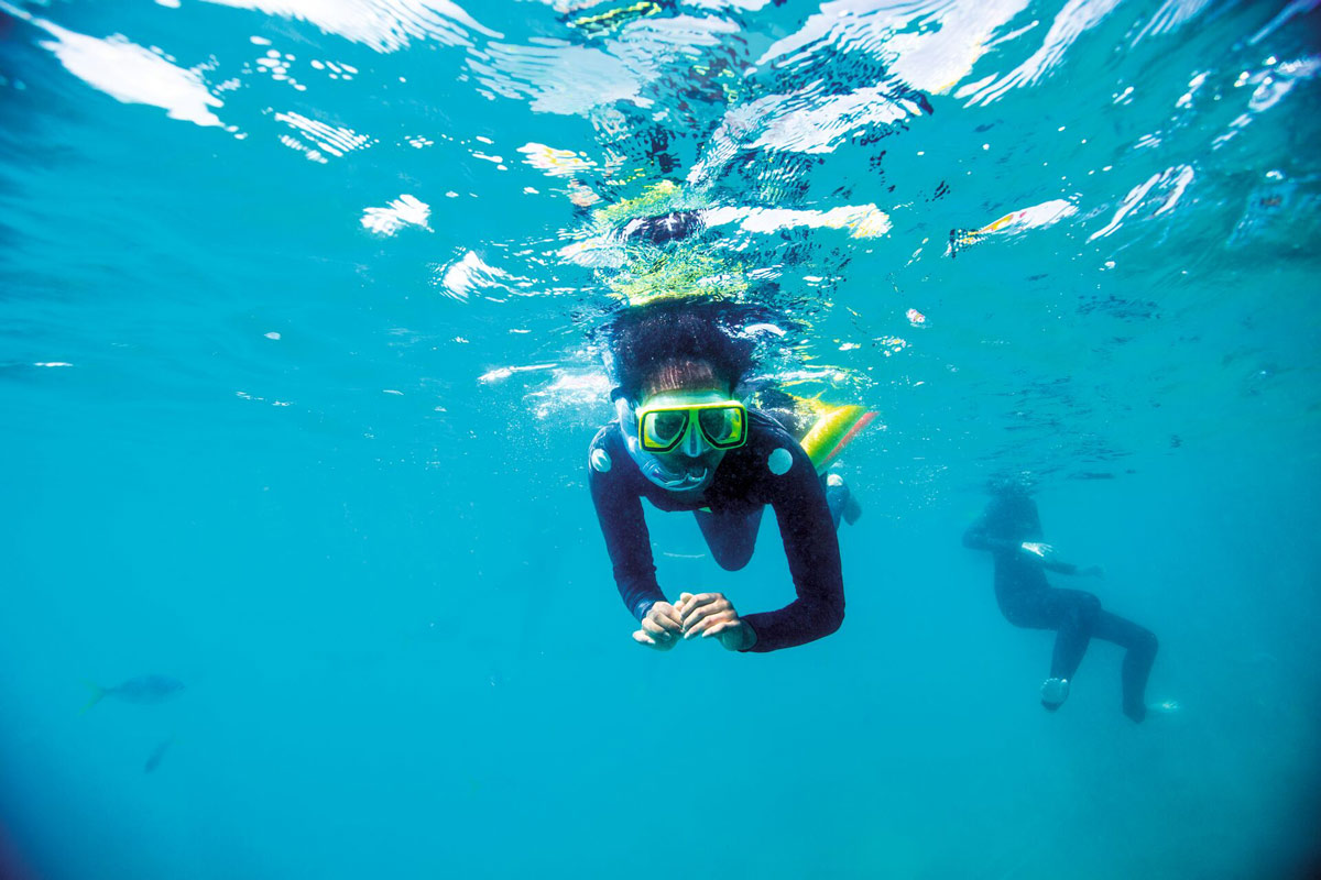 A Person Doing Snorkel In Blue Clear Waters