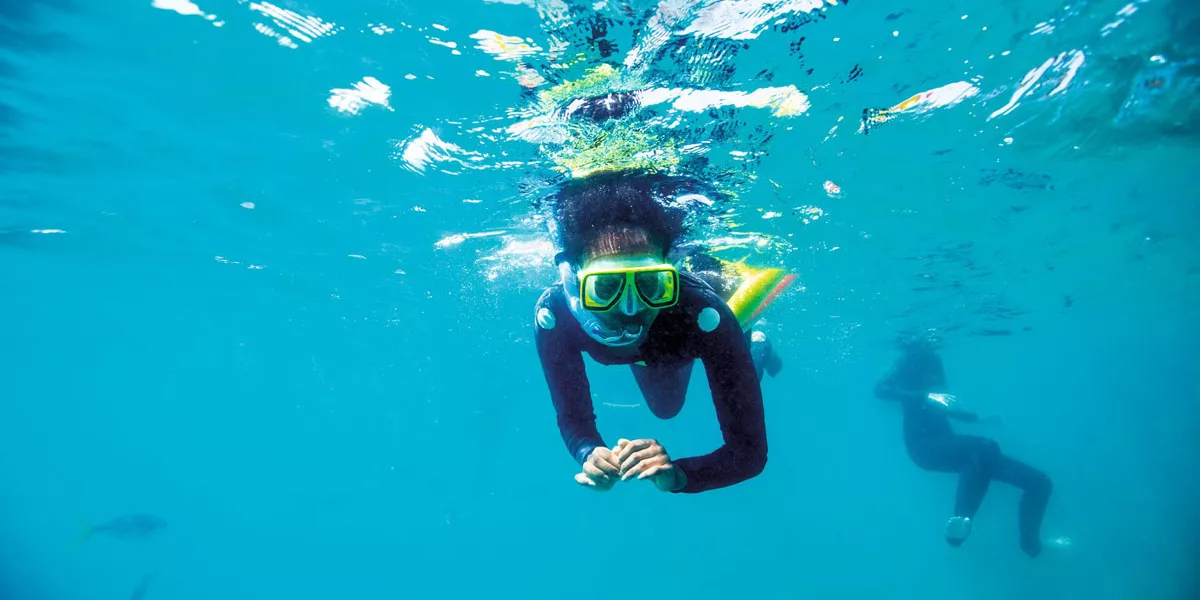 A Person Doing Snorkel In Blue Clear Waters