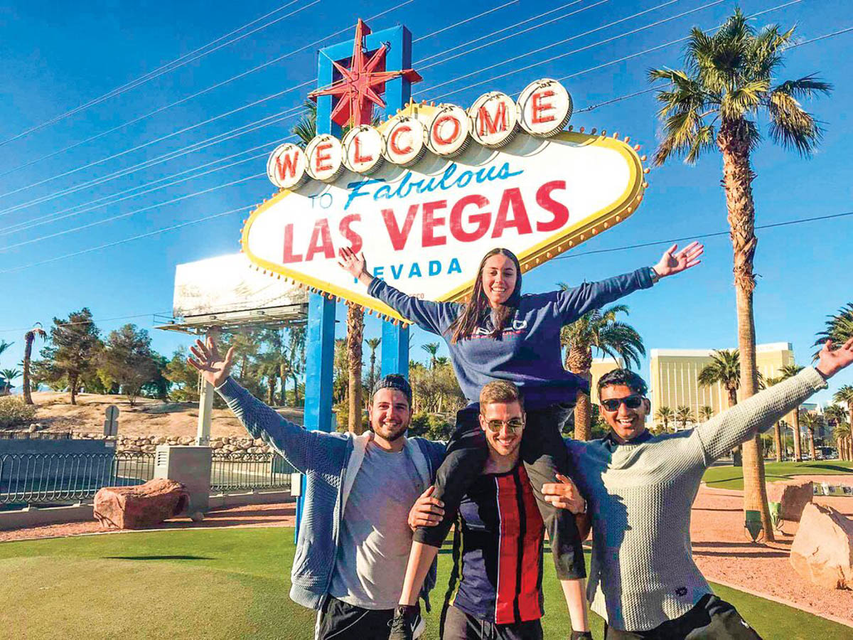 A group of people in front of the Las Vegas sign.