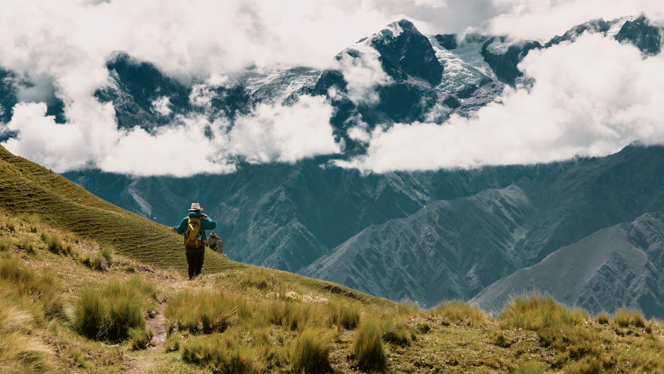 A person hikes through the breathtaking Andes Mountains on Contiki's Lima to Machu Picchu Road Trip Tour in Peru