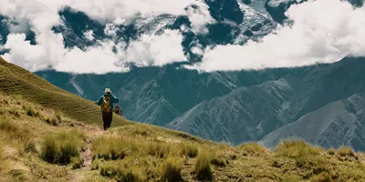 A person hikes through the breathtaking Andes Mountains on Contiki's Lima to Machu Picchu Road Trip Tour in Peru