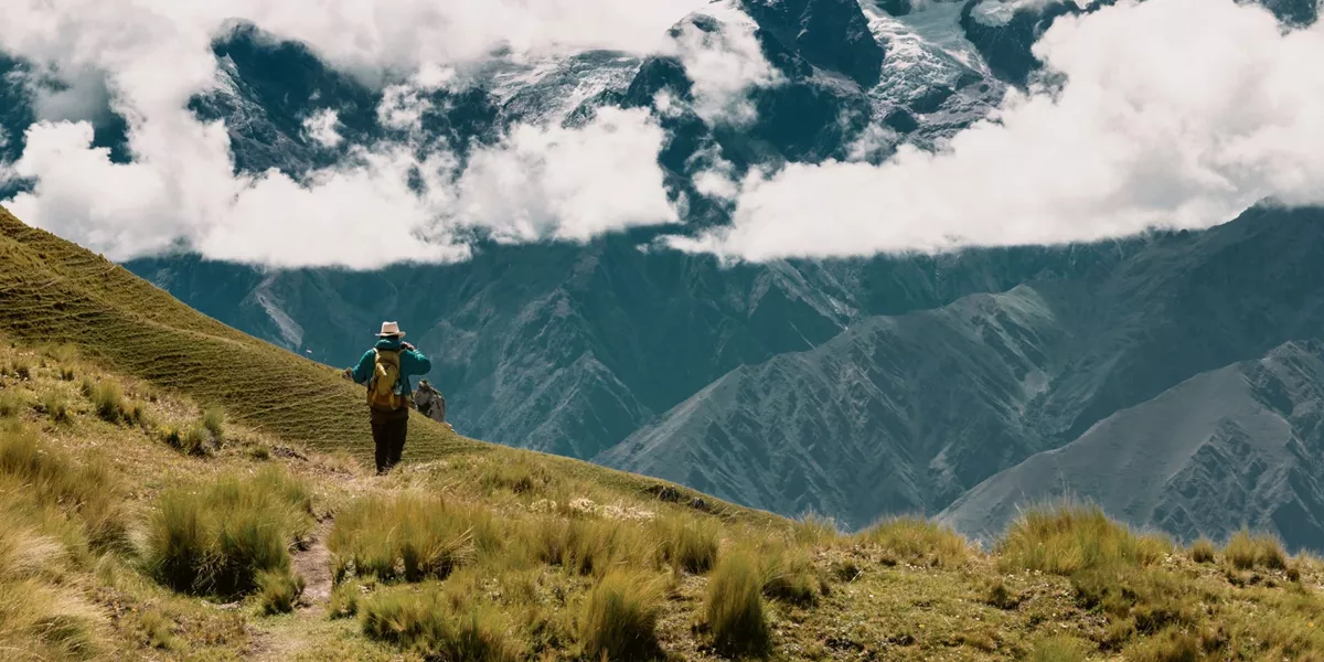 A person hikes through the breathtaking Andes Mountains on Contiki's Lima to Machu Picchu Road Trip Tour in Peru