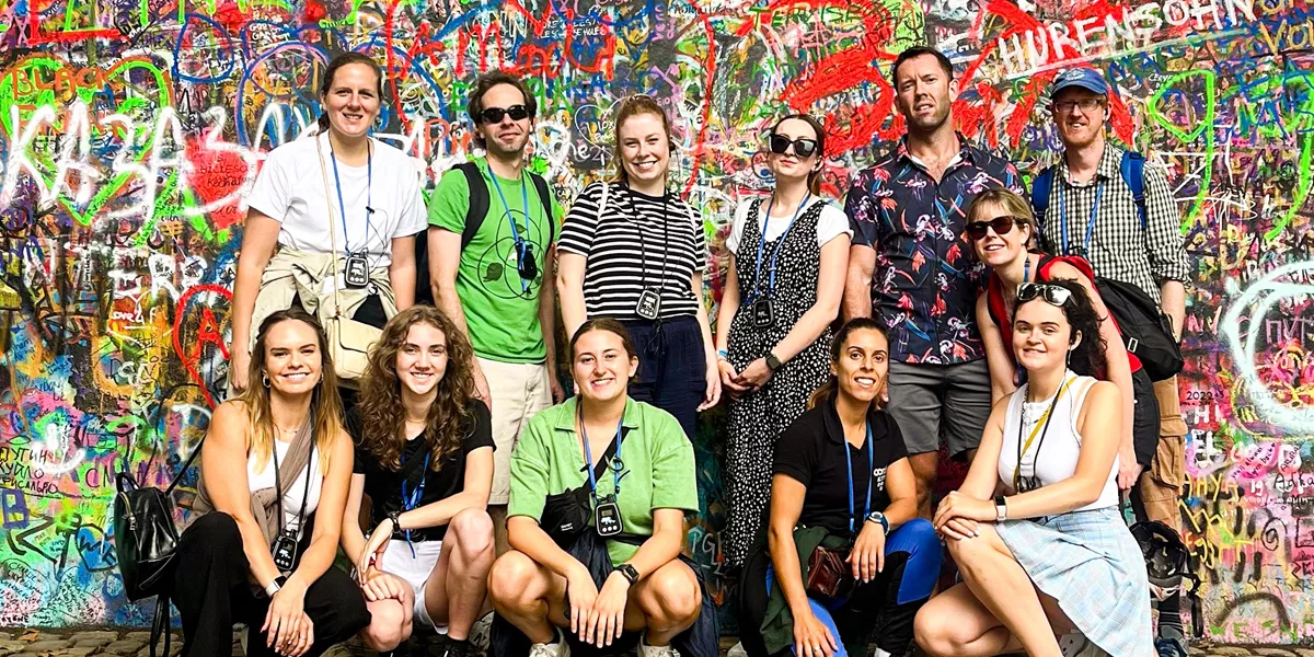 Group of travellers posing for a picture infront of a graffiti wall