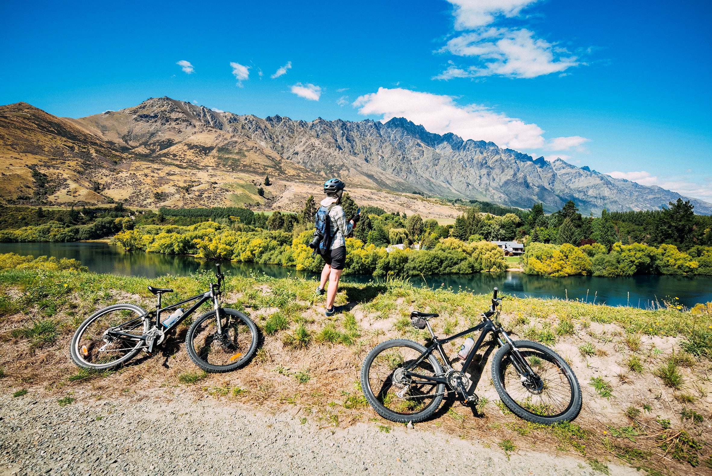 Traveler with Bikes by Lake, Queenstown, New Zealand