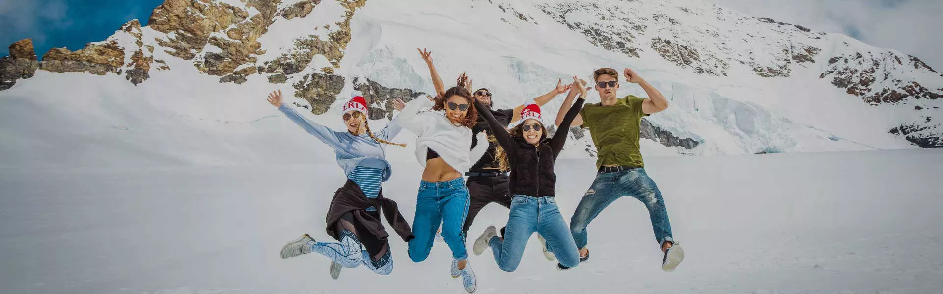 Group Jumping Together In The Snowy Mountains