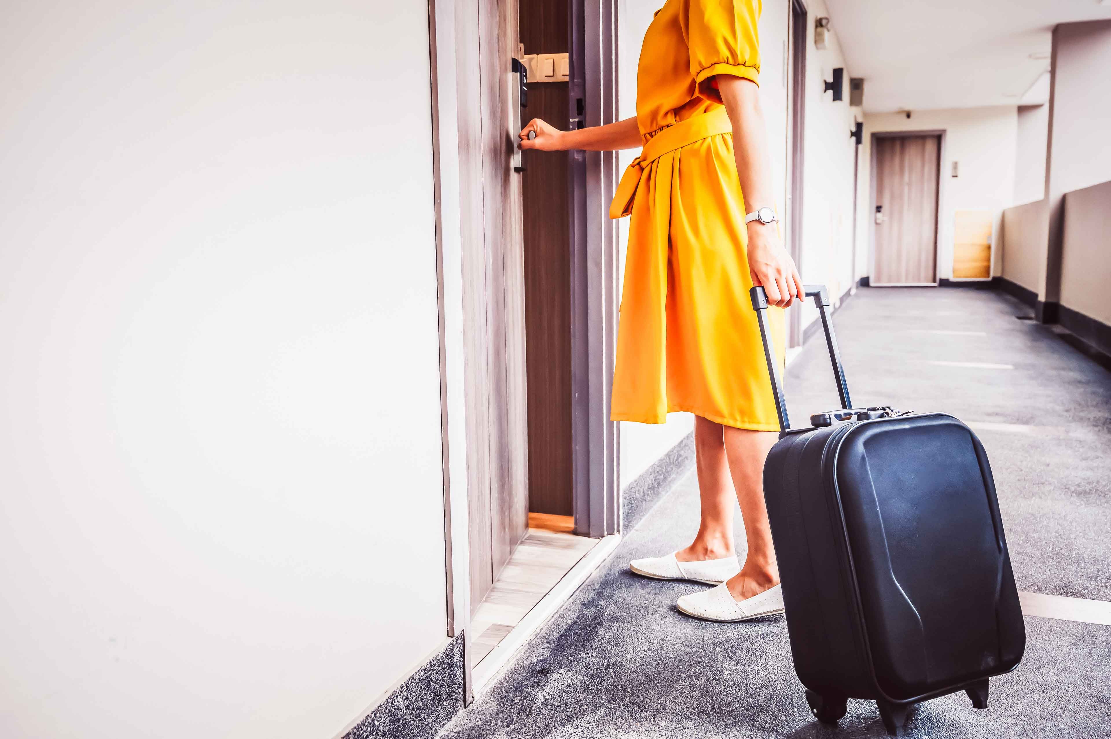 Shot View Of Tourist Woman Pulling Her Luggage To Her Hotel Room After Check In