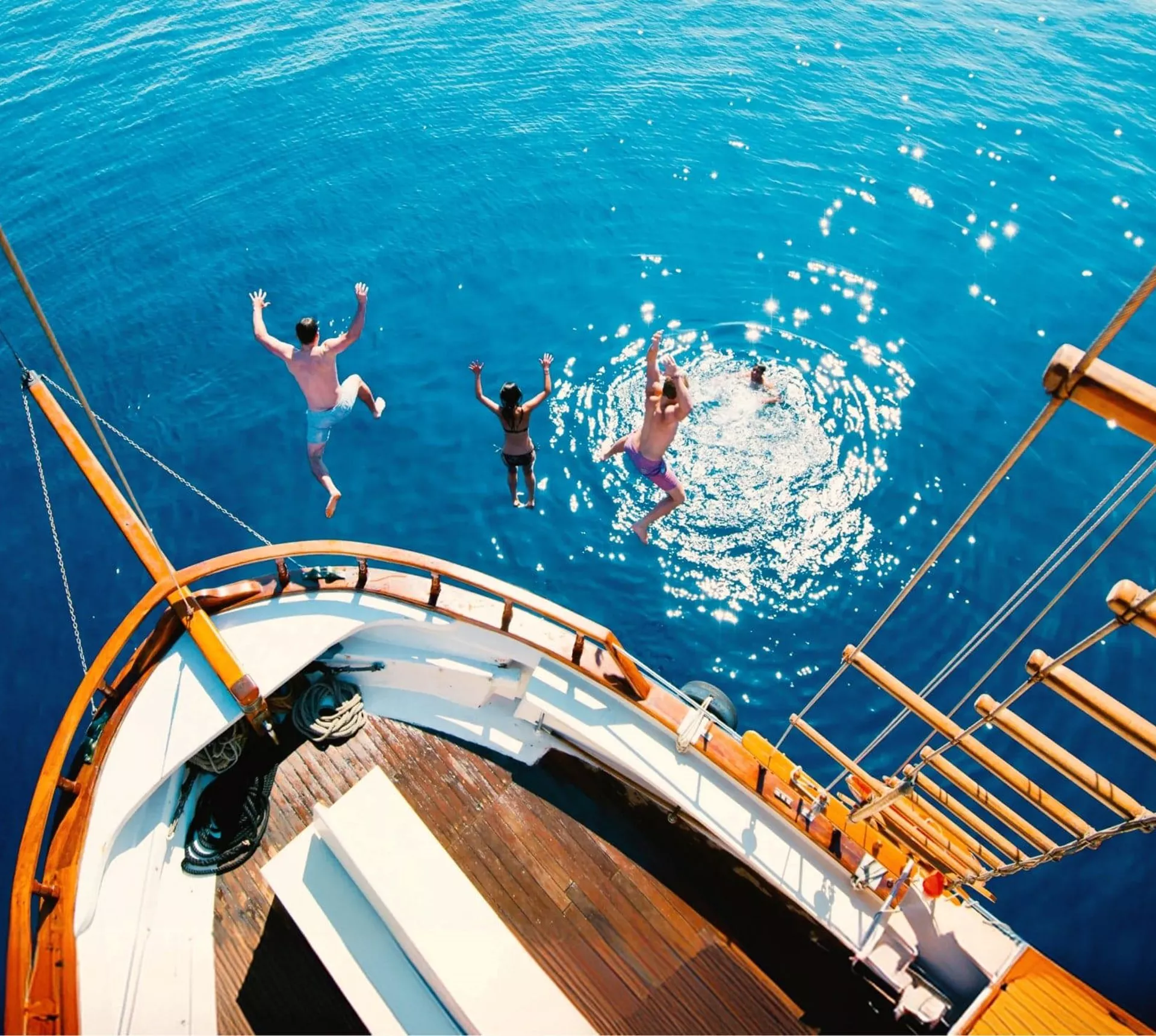Travellers jump from a sailing boat into the crystal-clear Aegean Sea on Contiki's Greek Island Hopping 35 to 45 Tour