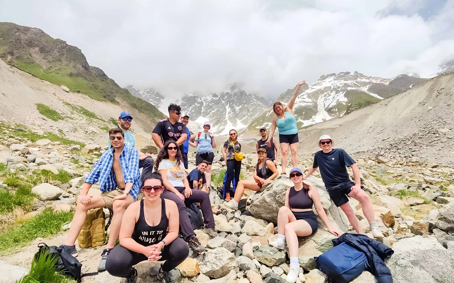 A group of young people smiling with the Rocky Mountains around them in Georgia.